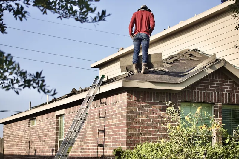 Professional roofer working on a residential roof in Martins Cove Farm